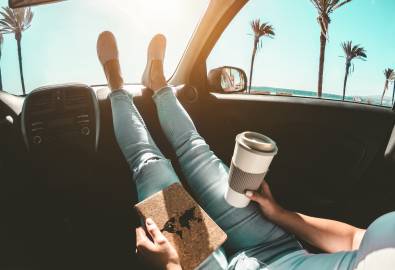 X_Woman drinking coffee paper cup inside car