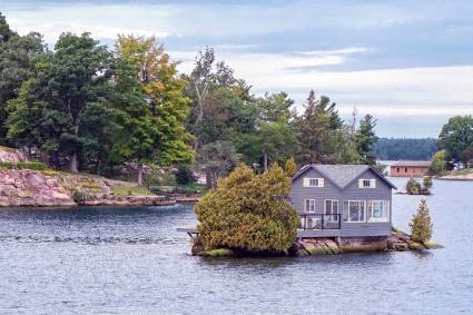 kleines Haus auf kleiner Insel, im Hintergrund noch mehr Inseln